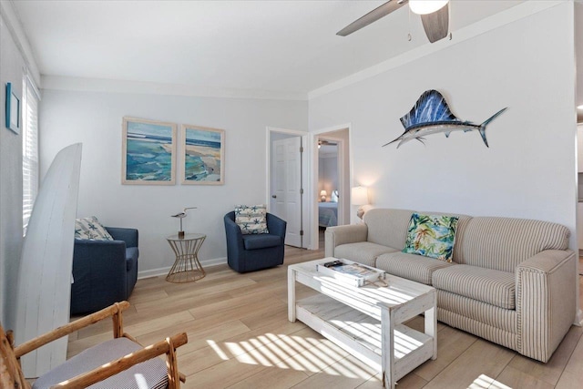 living room with vaulted ceiling, light wood-type flooring, ceiling fan, and ornamental molding