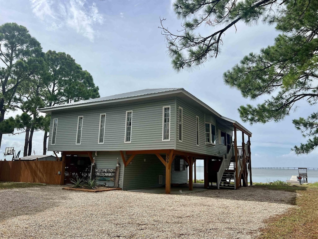 view of front of house with a water view, fence, and stairway