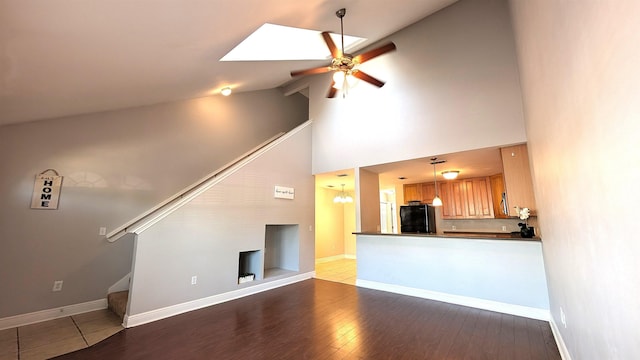 3320 Sugar Berry Way, Tallahassee, FL 32303 - unfurnished living room featuring baseboards, ceiling fan with notable chandelier, wood finished floors, stairway, and high vaulted ceiling
