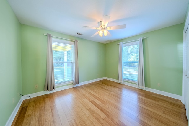 unfurnished room featuring plenty of natural light, ceiling fan, and light hardwood / wood-style flooring