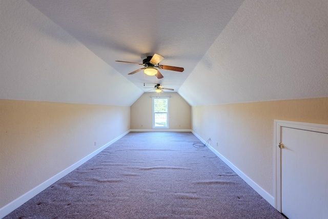 additional living space with a textured ceiling, carpet floors, ceiling fan, and lofted ceiling