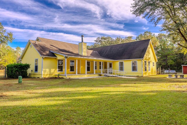 rear view of house featuring a yard and a patio