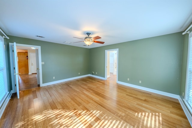 empty room with ceiling fan and light hardwood / wood-style floors