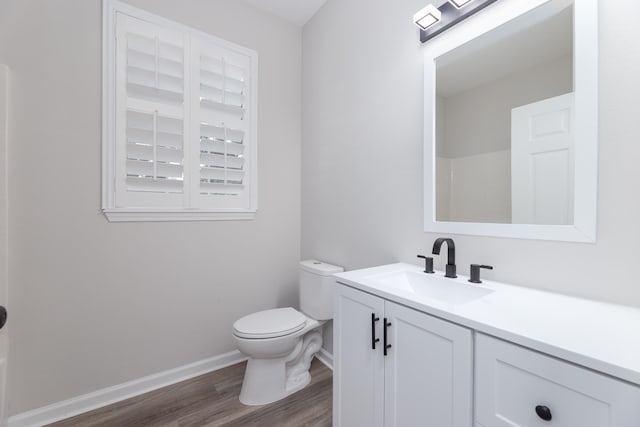 bathroom with toilet, vanity, hardwood / wood-style floors, and walk in shower