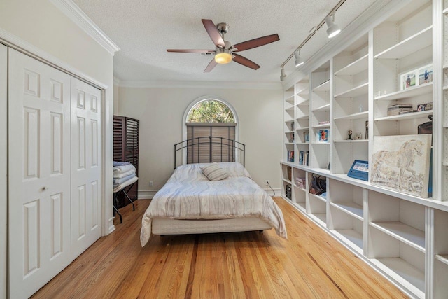 bedroom featuring ornamental molding, wood-type flooring, and a textured ceiling