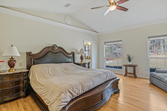 bedroom featuring crown molding, lofted ceiling, and light hardwood / wood-style flooring