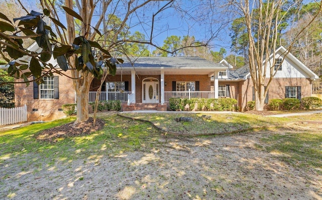 ranch-style home featuring covered porch and a front lawn