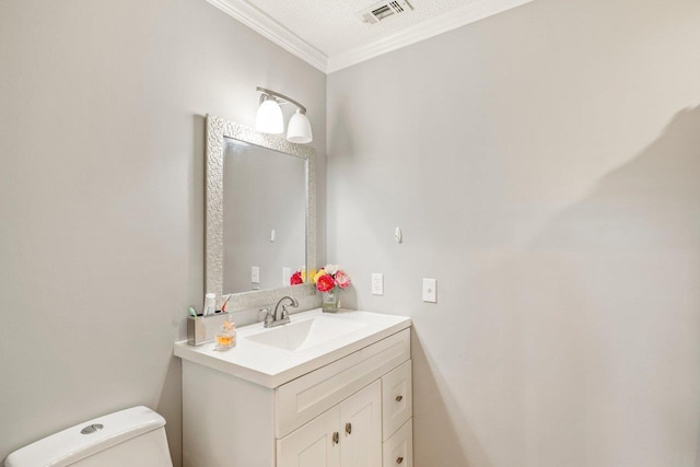 bathroom with ornamental molding, vanity, and toilet