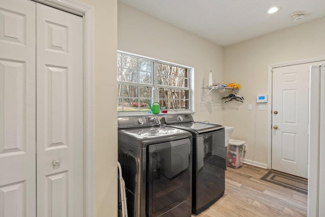 laundry room featuring separate washer and dryer and light hardwood / wood-style floors