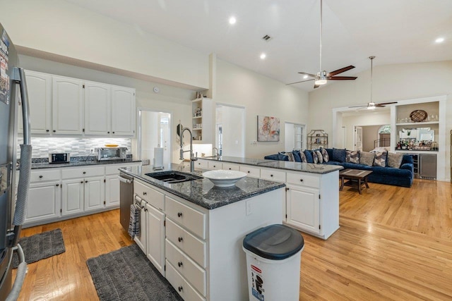 kitchen with sink, white cabinetry, light wood-type flooring, an island with sink, and stainless steel appliances