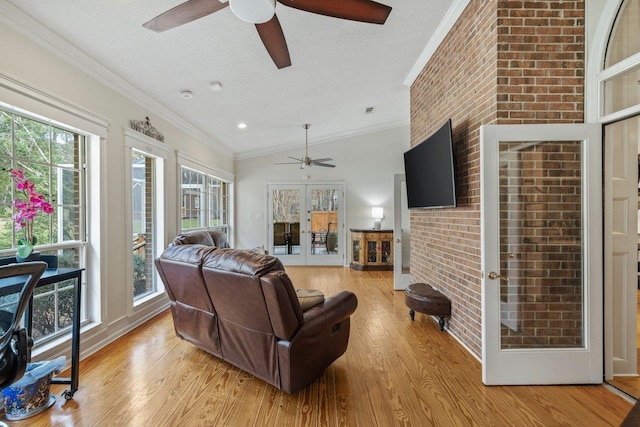 living room featuring ornamental molding, light hardwood / wood-style floors, a textured ceiling, and french doors