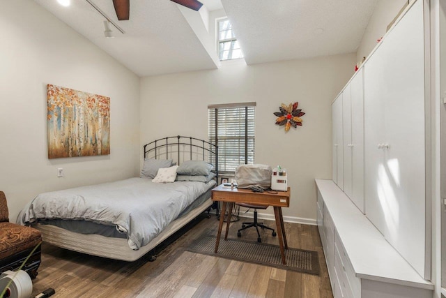 bedroom featuring lofted ceiling, wood-type flooring, and a textured ceiling