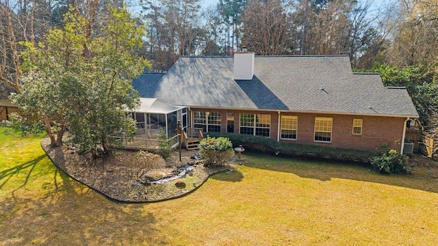 rear view of house with a wooden deck, central AC, a lawn, and a sunroom