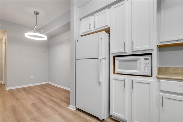 2801 Chancellorsville Dr Unit 1217, Tallahassee, FL 32312 - kitchen featuring white appliances, light wood finished floors, white cabinetry, light countertops, and pendant lighting