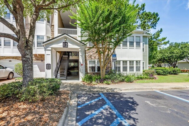2801 Chancellorsville Dr Unit 1217, Tallahassee, FL 32312 - view of building exterior featuring stairs and uncovered parking