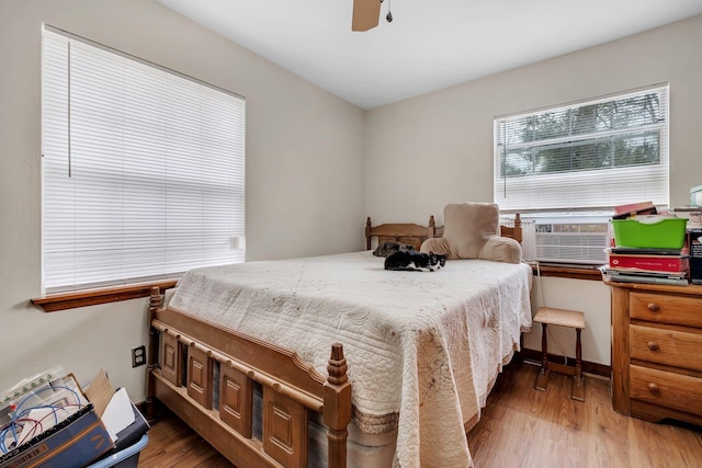 bedroom with cooling unit, ceiling fan, and dark hardwood / wood-style floors