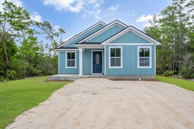 1695 Landing St, Carrabelle, FL 32322 - view of front of property featuring a porch, a front lawn, and board and batten siding