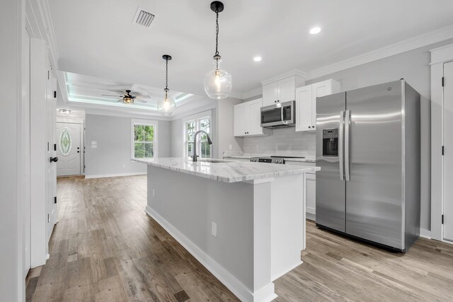 1695 Landing St, Carrabelle, FL 32322 - kitchen featuring appliances with stainless steel finishes, ornamental molding, white cabinets, light wood-type flooring, and ceiling fan