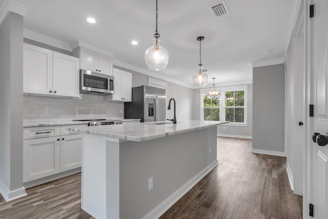1695 Landing St, Carrabelle, FL 32322 - kitchen with appliances with stainless steel finishes, crown molding, an island with sink, white cabinetry, and dark wood-style floors