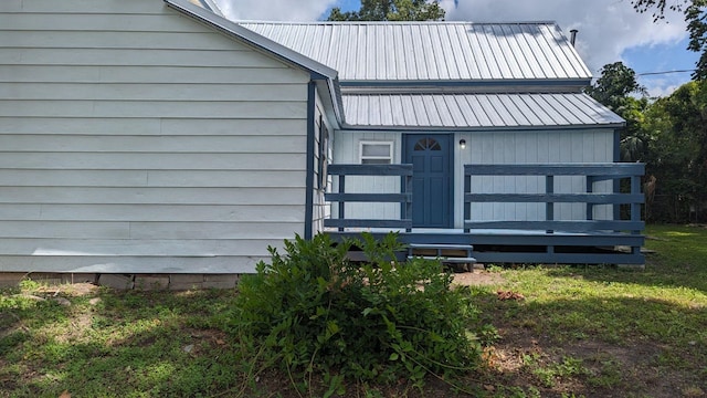 view of exterior entry with a yard