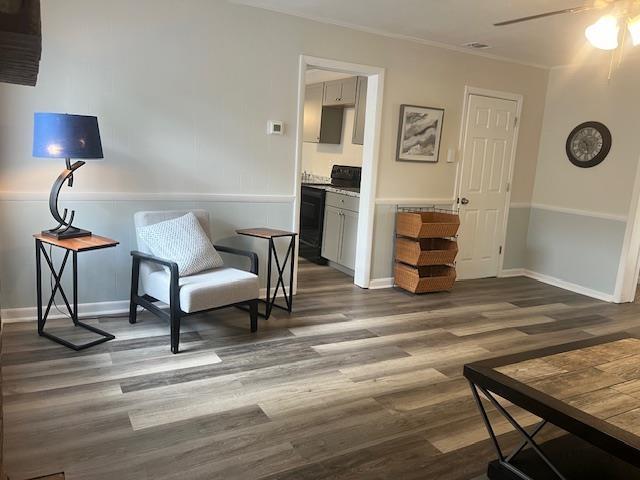 sitting room featuring crown molding, ceiling fan, and dark hardwood / wood-style floors