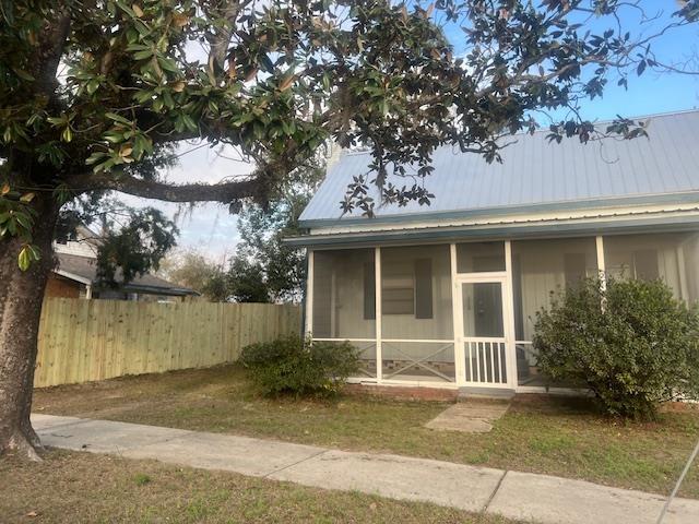 view of side of home featuring a yard and a sunroom