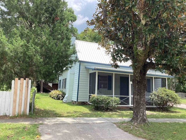 view of front of property with a front yard and a sunroom