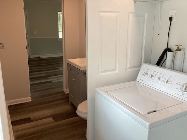 clothes washing area with washer / dryer and dark wood-type flooring