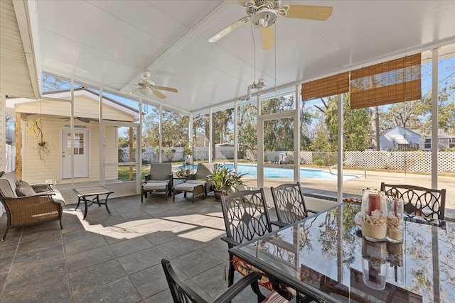 sunroom with ceiling fan, a healthy amount of sunlight, and vaulted ceiling