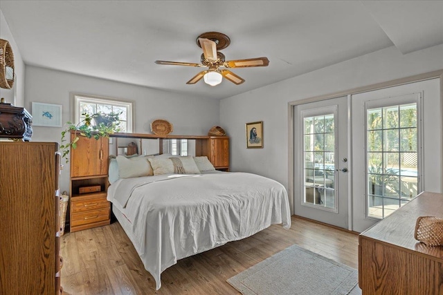 bedroom featuring access to exterior, light hardwood / wood-style floors, and multiple windows