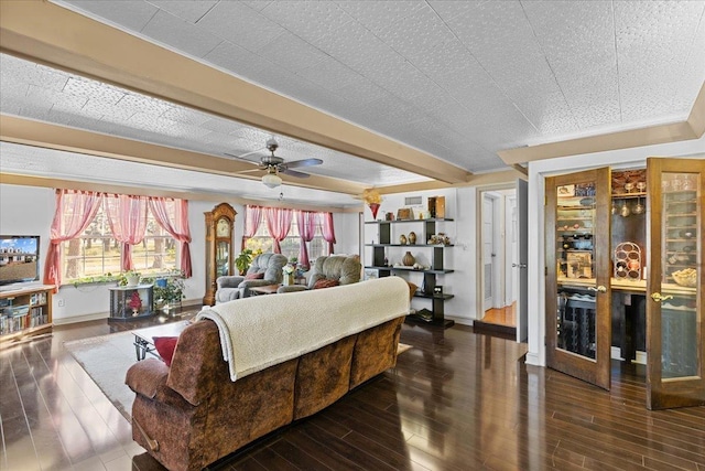 living room featuring ceiling fan, dark hardwood / wood-style flooring, and a textured ceiling