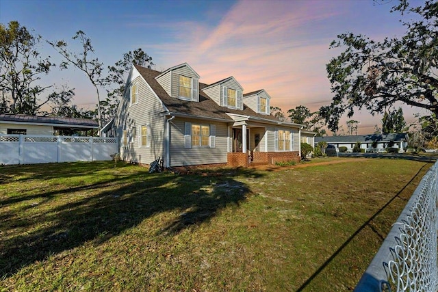 cape cod-style house featuring a lawn