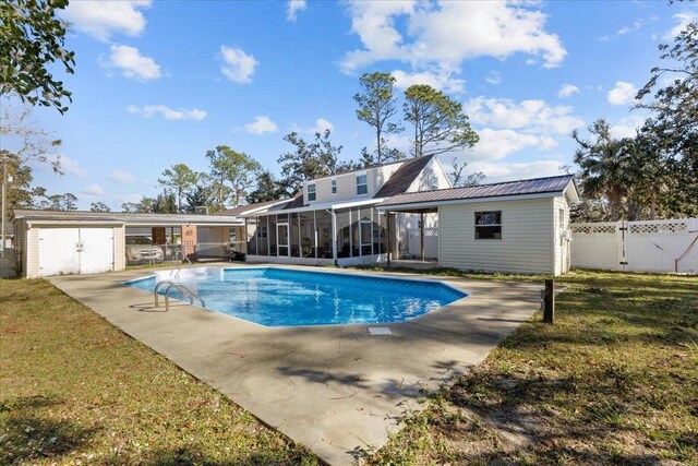 view of swimming pool with a patio area, a storage unit, a lawn, and a sunroom