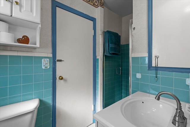 bathroom featuring vanity, an enclosed shower, tile walls, and toilet