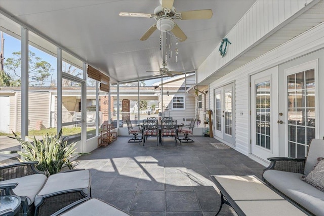 sunroom / solarium with plenty of natural light, lofted ceiling, and ceiling fan