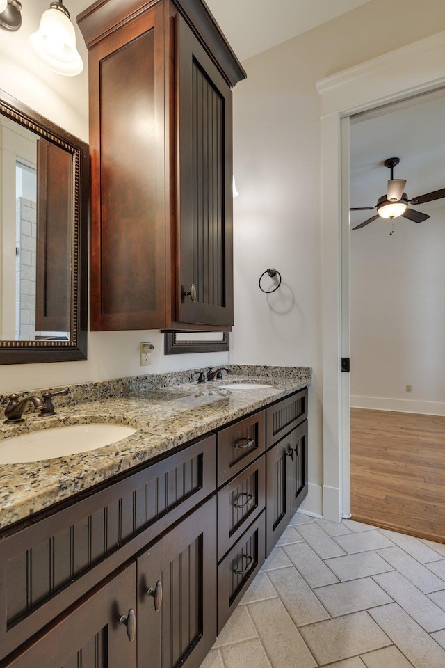 bathroom with ceiling fan, a sink, and baseboards