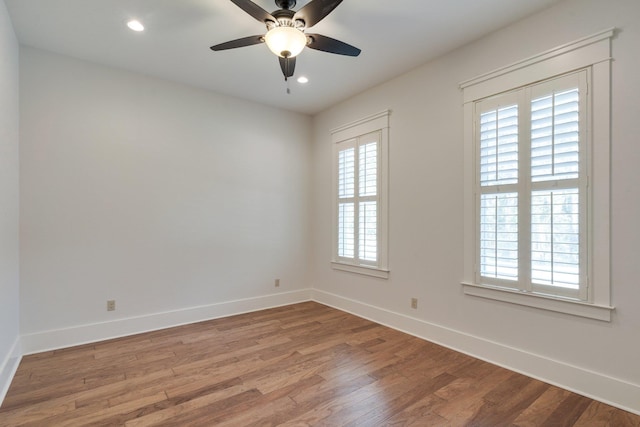 empty room with ceiling fan, baseboards, wood finished floors, and recessed lighting