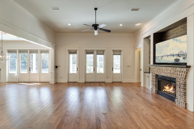 unfurnished living room featuring visible vents, crown molding, and wood finished floors