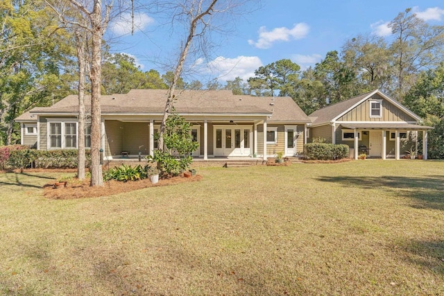 back of property featuring a yard, board and batten siding, and french doors