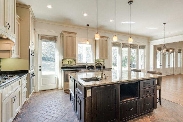 kitchen featuring ornamental molding, a sink, brick floor, cream cabinetry, and backsplash