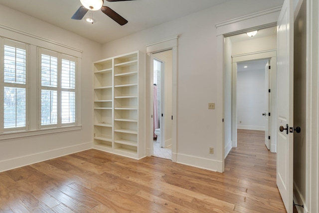 unfurnished bedroom featuring ceiling fan, light wood-type flooring, and baseboards