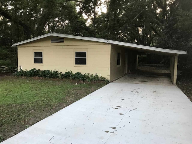 view of side of property featuring a carport and a yard