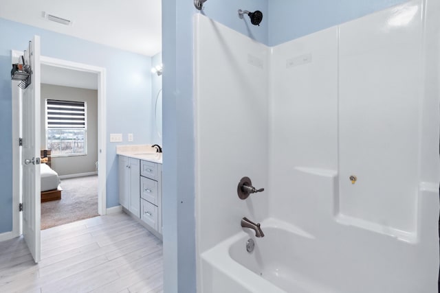 bathroom featuring vanity, hardwood / wood-style flooring, and shower / tub combination