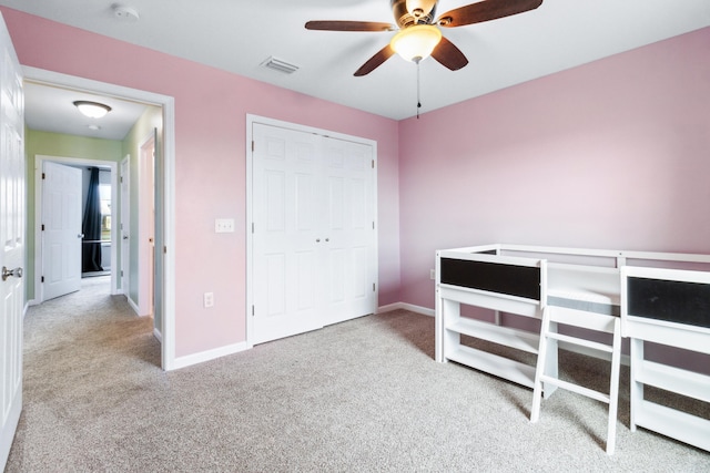 carpeted bedroom featuring a closet and ceiling fan