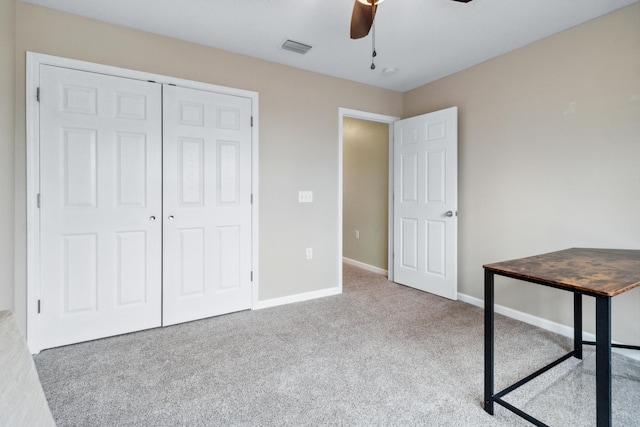 unfurnished bedroom with ceiling fan, light colored carpet, and a closet