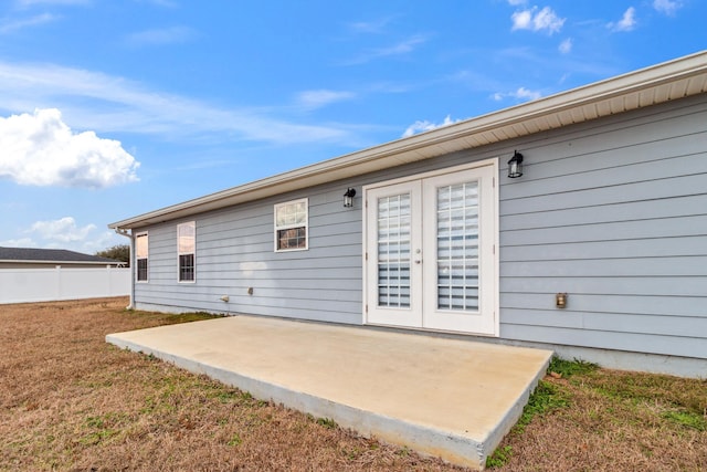 rear view of house featuring french doors, a patio, and a lawn