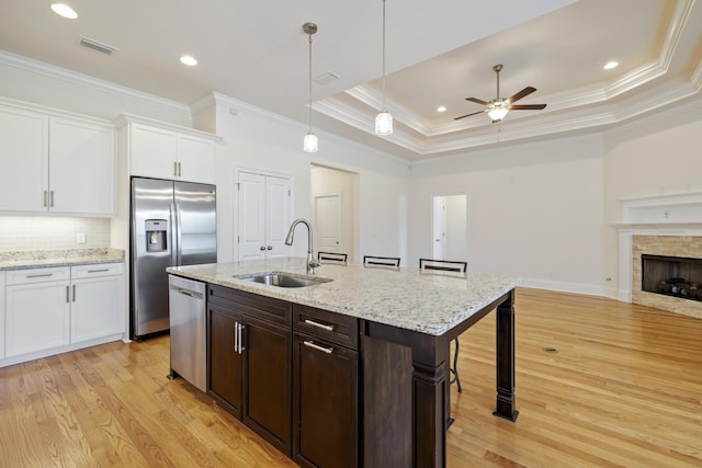 kitchen with a breakfast bar, sink, white cabinetry, a raised ceiling, and stainless steel appliances