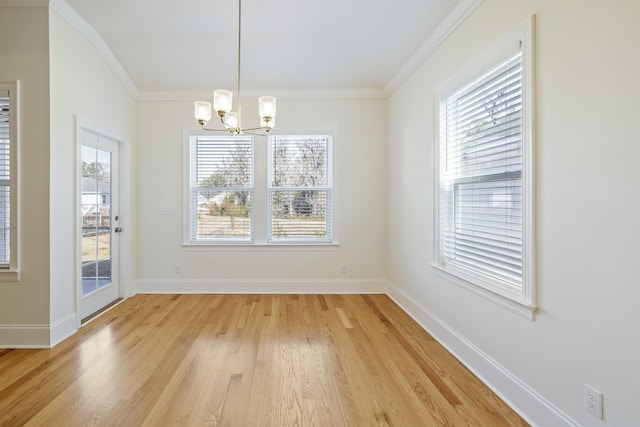 unfurnished dining area with crown molding, an inviting chandelier, and light hardwood / wood-style flooring