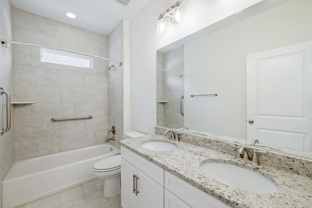 full bathroom featuring tiled shower / bath, vanity, toilet, and tile patterned flooring