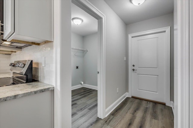 interior space featuring hardwood / wood-style floors, backsplash, and stainless steel range oven